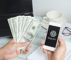 A person holding a fan of hundred-dollar bills in one hand and a smartphone displaying the ChatGPT logo in the other hand, with a laptop, coffee cup, eyeglasses, and a notepad on a desk in the background. Caption: "Earn Money Effortlessly: Discover Lucrative Opportunities with ChatGPT – No Investment Needed!"